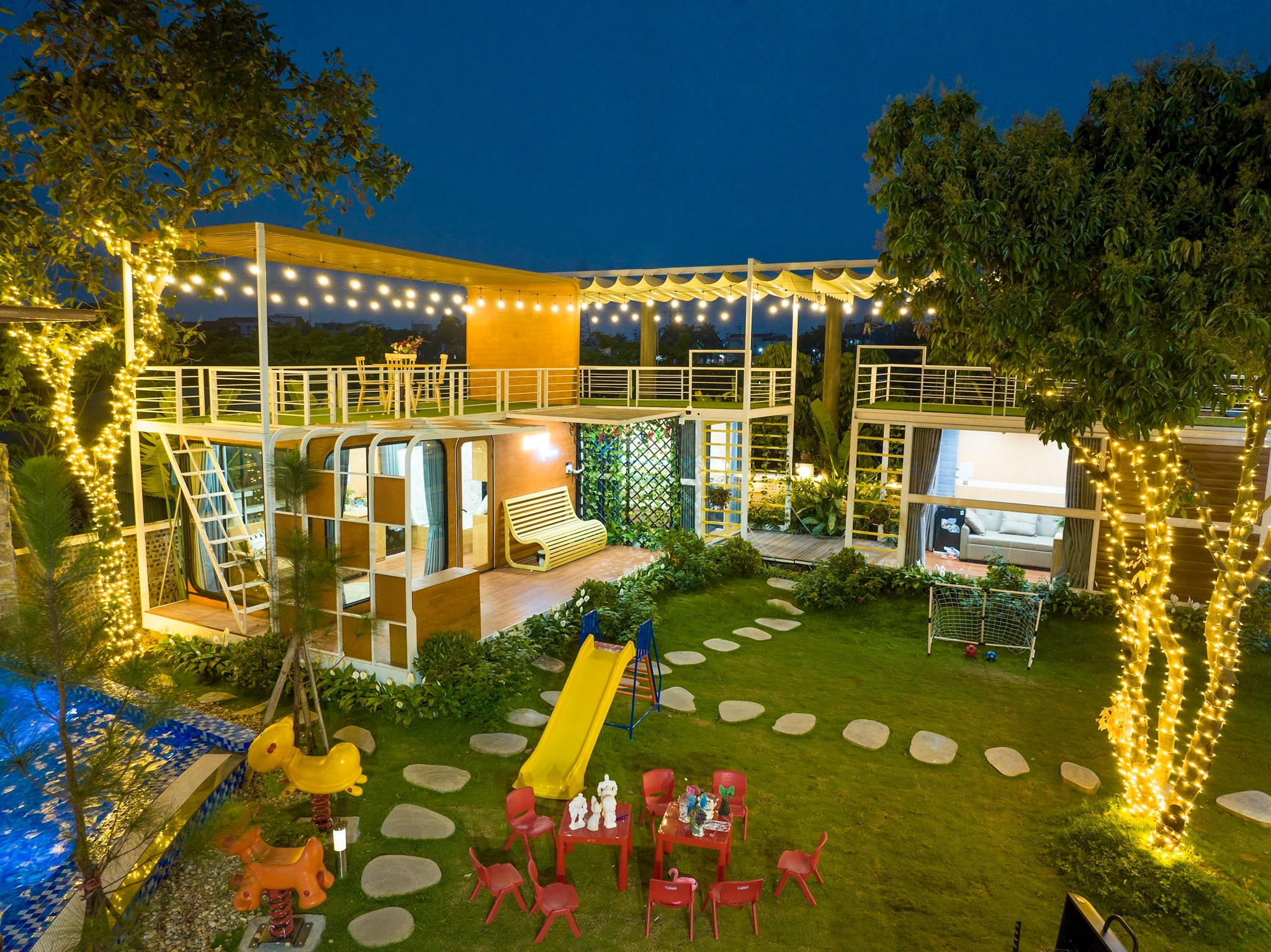 Sân vườn sắp đặt tiểu cảnh, xích đu, cầu trượt cho trẻ và bàn trà cho người lớn. 