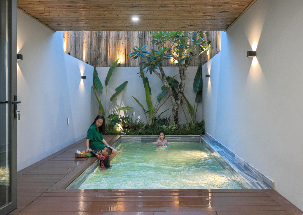 Bể bơi bố trí ở sân sau nhà, cạnh phòng khách và ngay dưới giếng trời